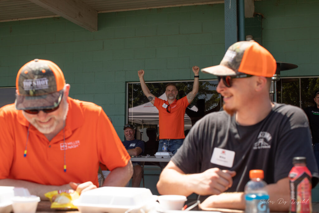 three men eating lunch at shooting event