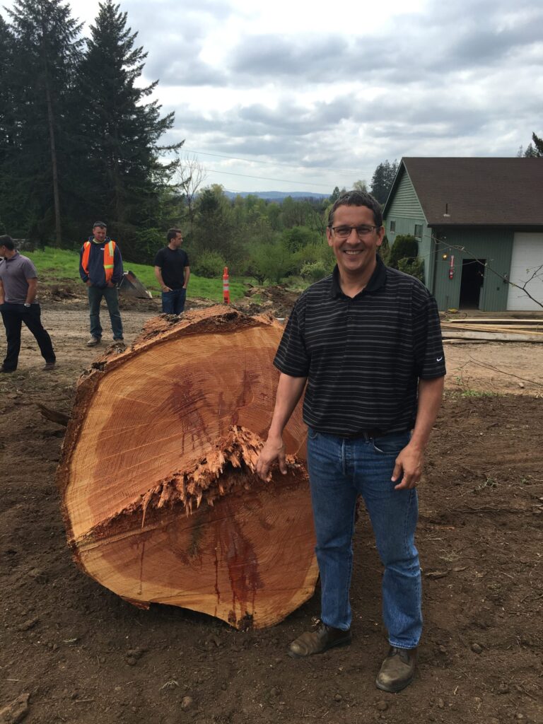 man standing with large log