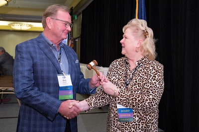 man handing woman a gavel