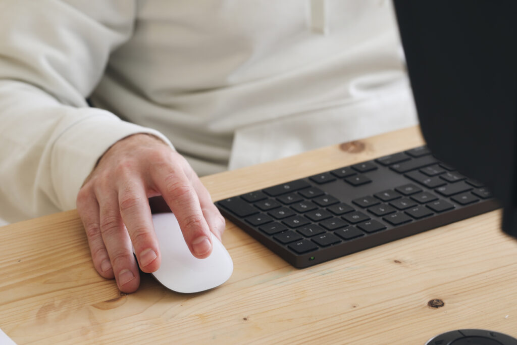 hand on computer mouse and keyboard