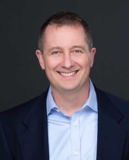 smiling man wearing blue shirt and jacket