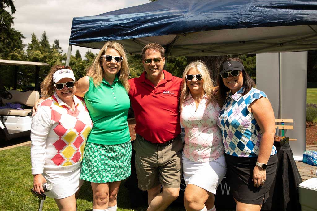 four ladies and a man in colorful golf clothes