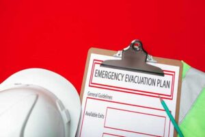 hard hat and clipboard with emergency evacuation plan printed on it