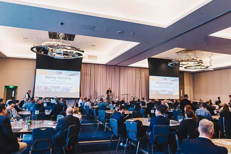 shot of room of people with projector screens