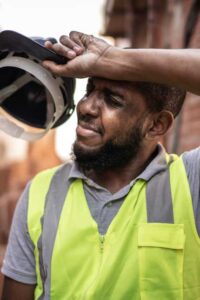 construction worker wiping forehead in heat