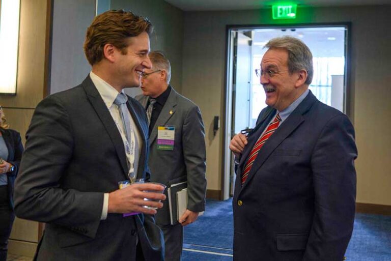 two men wearing ties talking and laughing