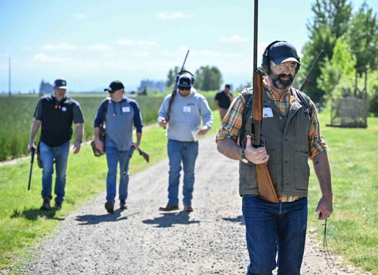 four men with shooting gear and rifles