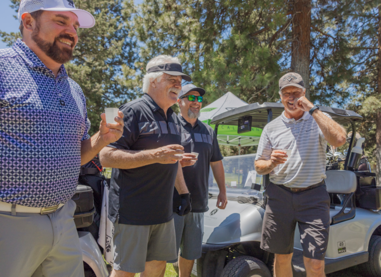 four smiling golfers