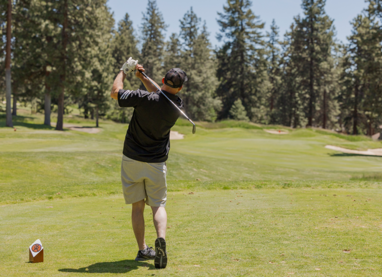 man hitting a golf ball