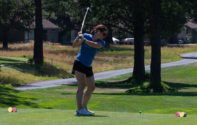 woman swinging golf club