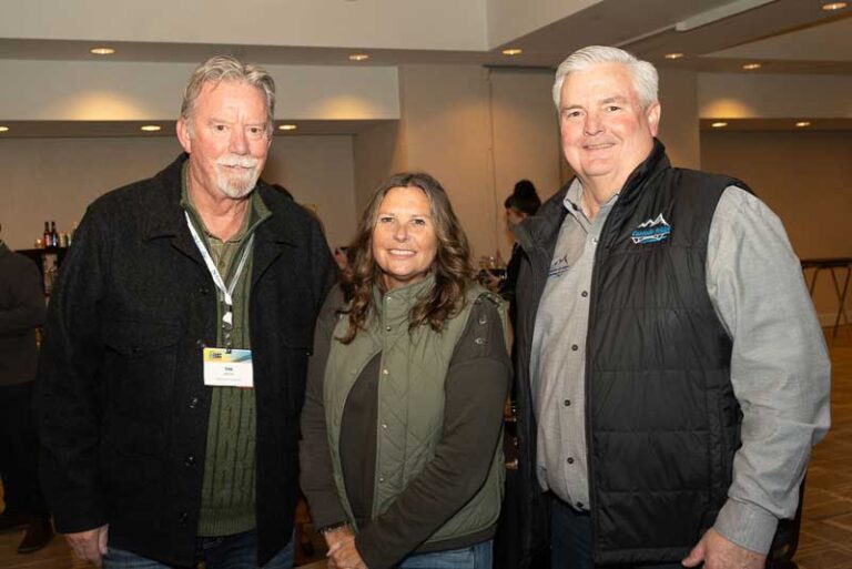 two men and a woman smiling