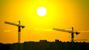 sunny sky and construction cranes