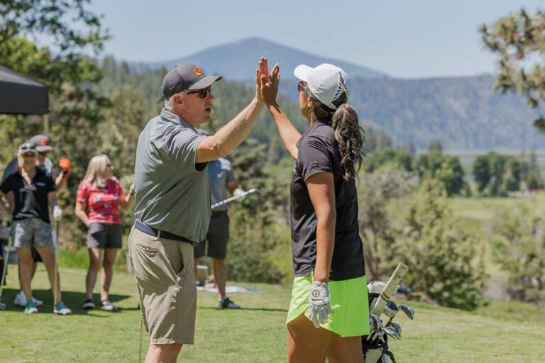 man and woman golfers high five
