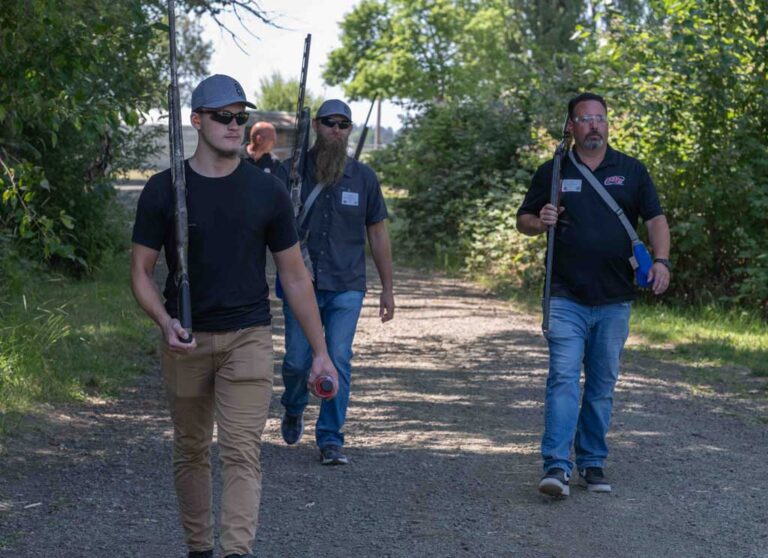 three men walking carrying skeet rifles
