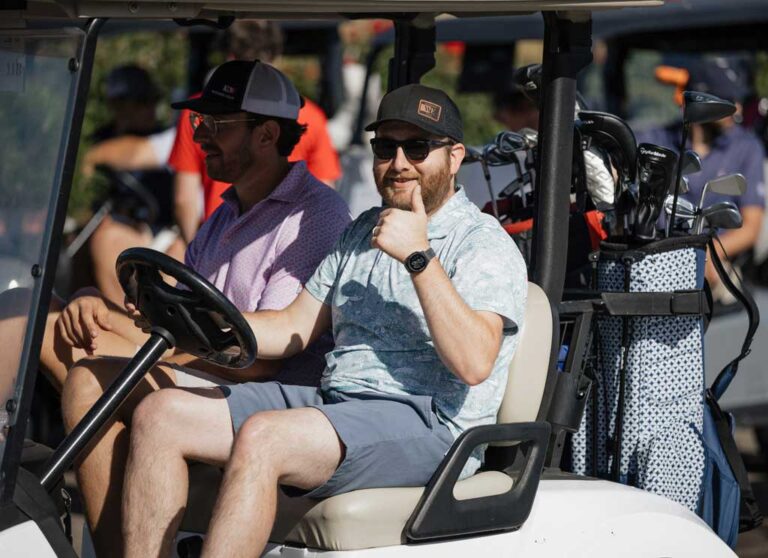 man with thumbs up in golf cart