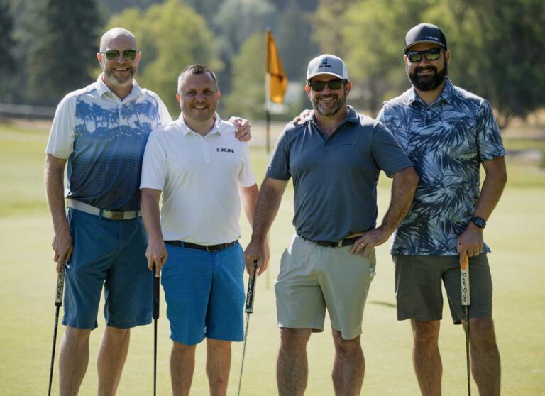 four smiling golfers
