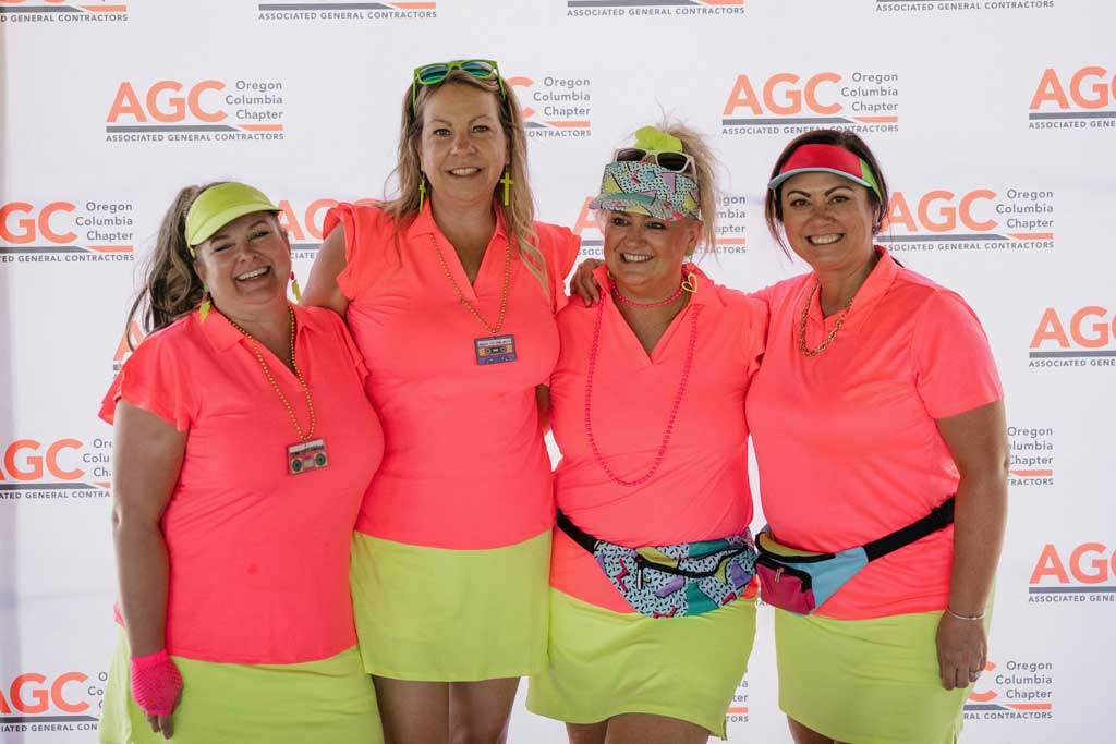 four smiling women wearing bright clothes