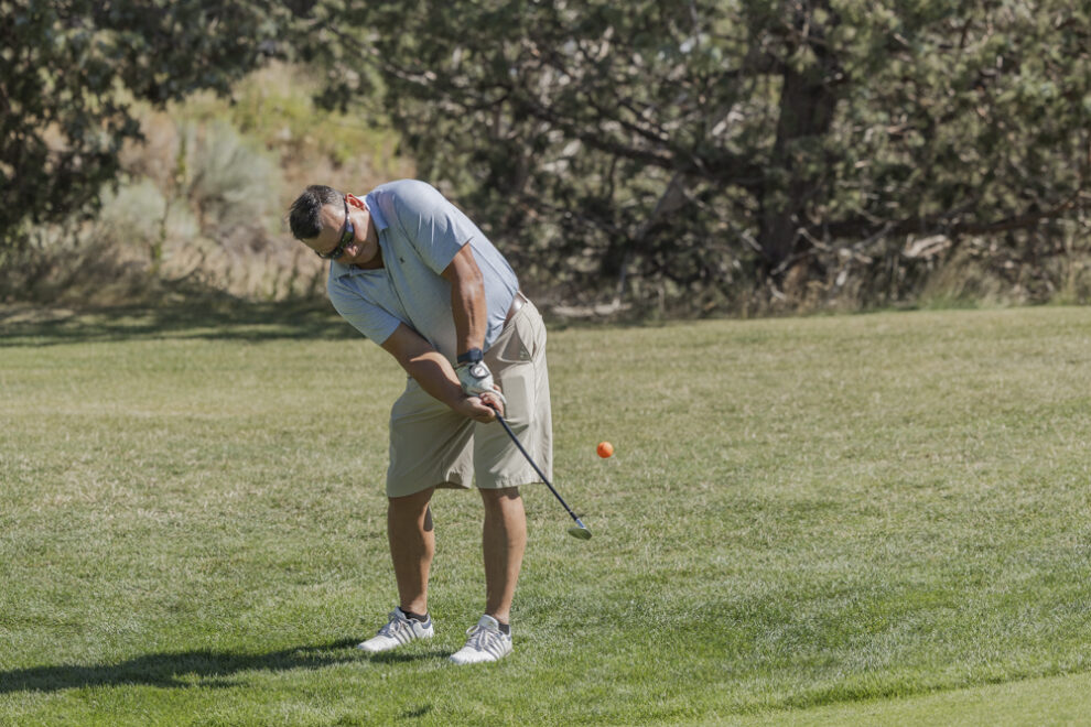 golfer hitting orange ball