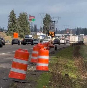 traffic cones on roadway with cars and trucks