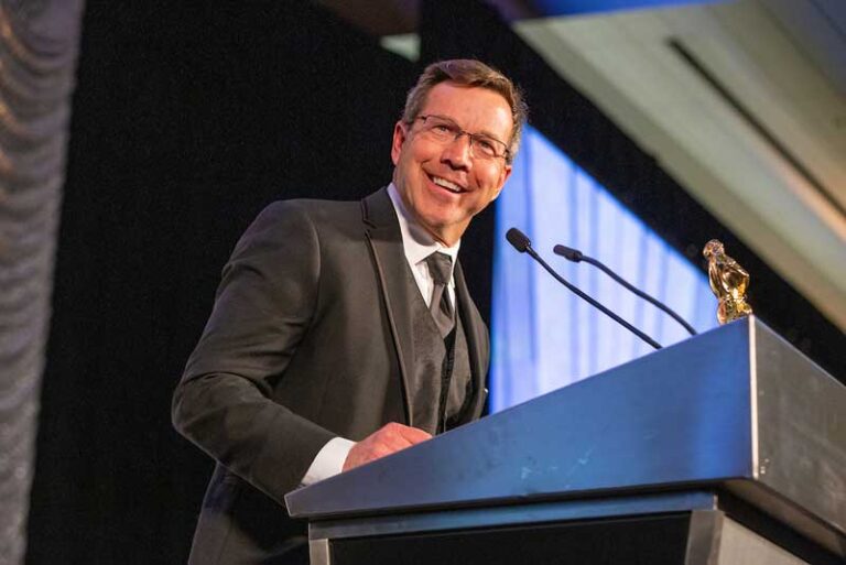smiling man in suit at podium