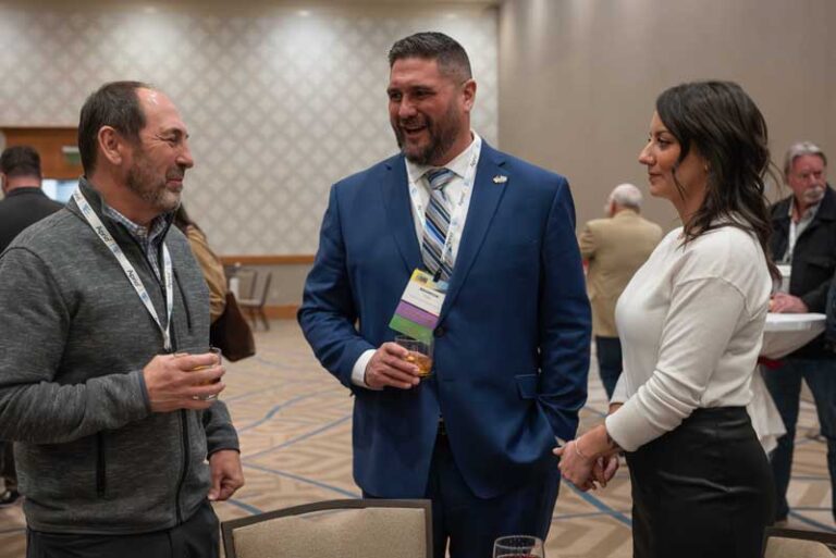 man in a suit smiling and talking with others