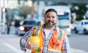 smiling construction worker holding hardhat