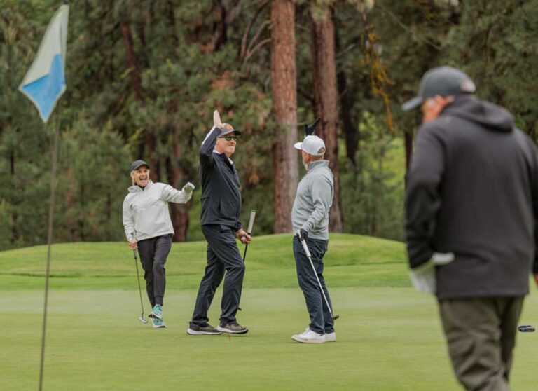 two of four golf players high fiving