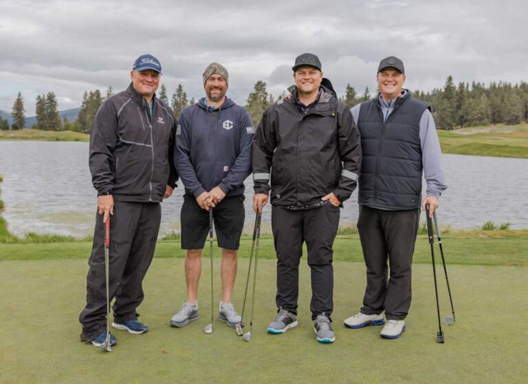 four golfers standing in a row
