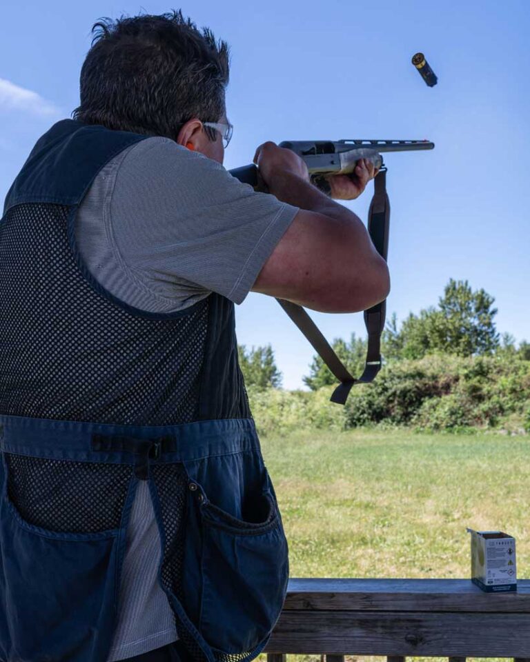 man in vest shooting rifle