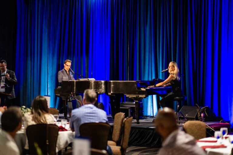 a man and woman dueling pianos