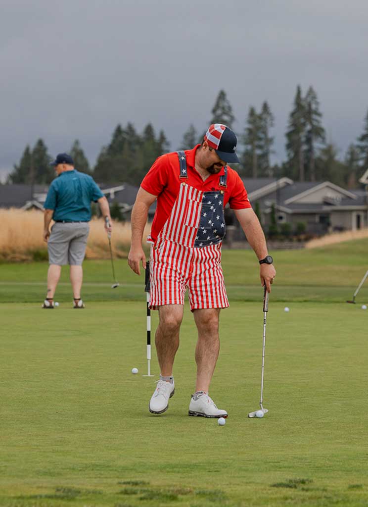 a man wearing patriotic overalls at a golf tournament