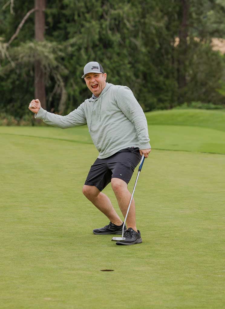 a man with a fist in the air celebrating a golf shot