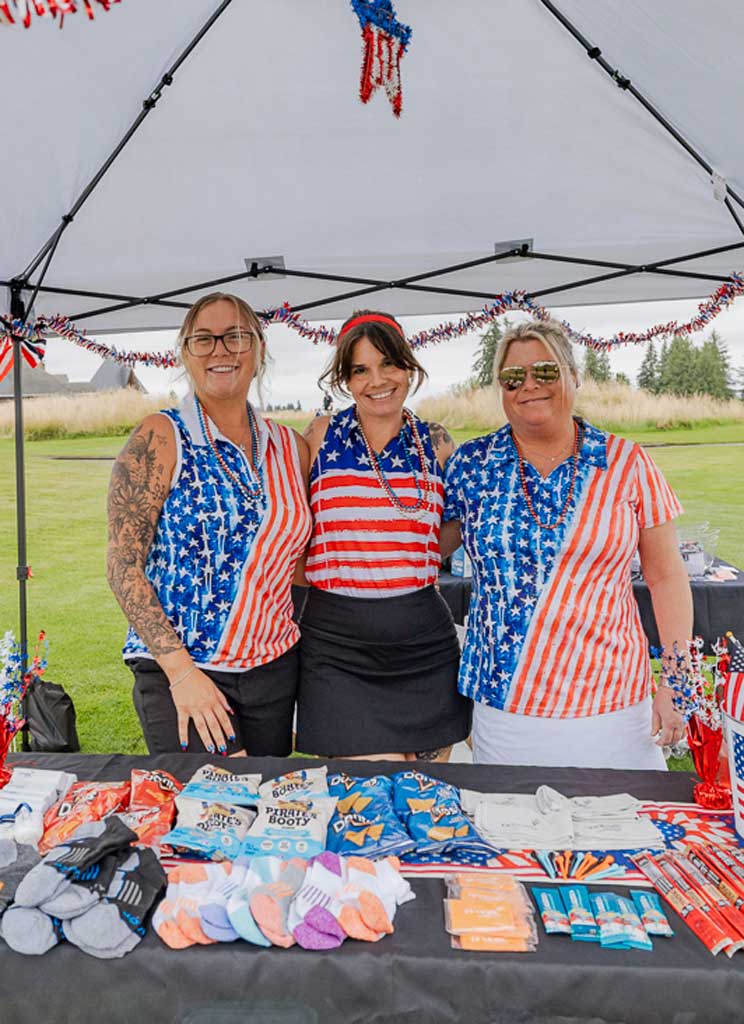 three ladies smiling at a golf tournament