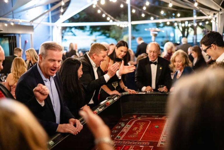 people playing at a casino table with a man celebrating